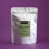 Envase Doypack plateada con etiqueta verde de Hojas de Salvia Amman Tea Blends, con propiedades calmantes y digestivas, sobre un fondo morado.
