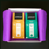Caja de regalo de Amman Tea Blends abierta con papel morado, que incluye dos estuches de té de 60g: Green Cedrón (té verde con hojas de cedrón) y Green Chai (té verde con especias).