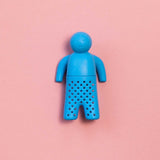 Infusor de té de silicona en forma de figura humana color azul sobre fondo rosado.
