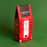 Caja de té Puerh de Amman Pure Tea, té rojo fermentado de sabor terroso, empaque rojo sobre fondo verde.
